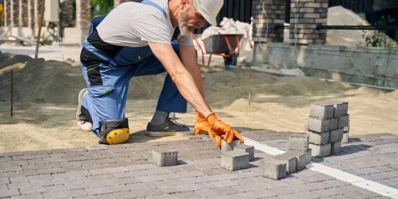 Skilled builder paving road on construction site